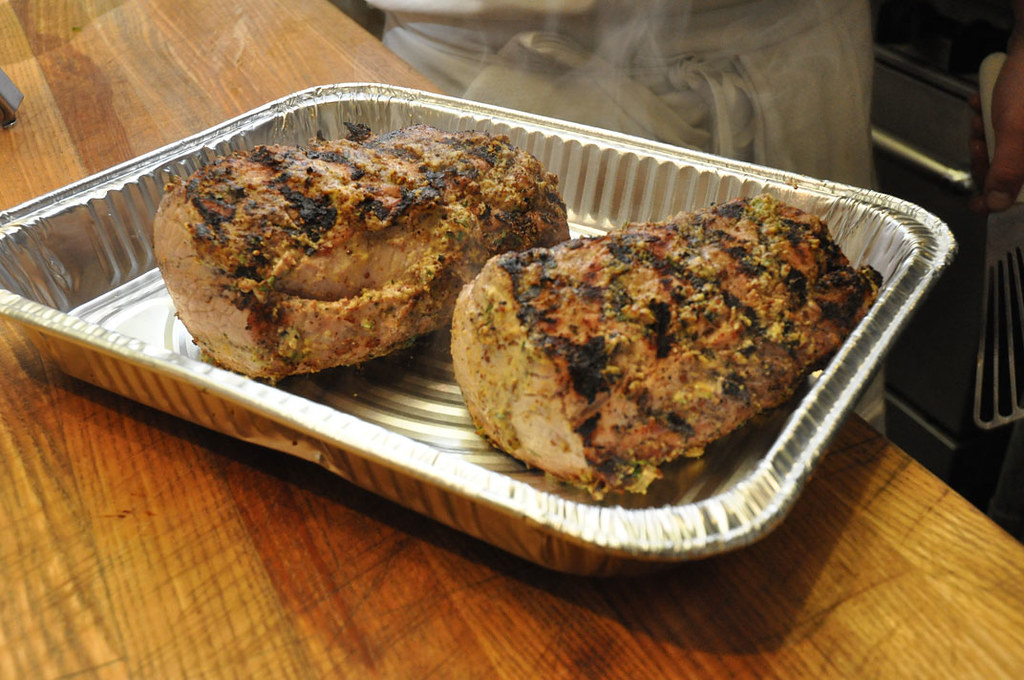 Two cooked and seasoned pork loins in a pan.