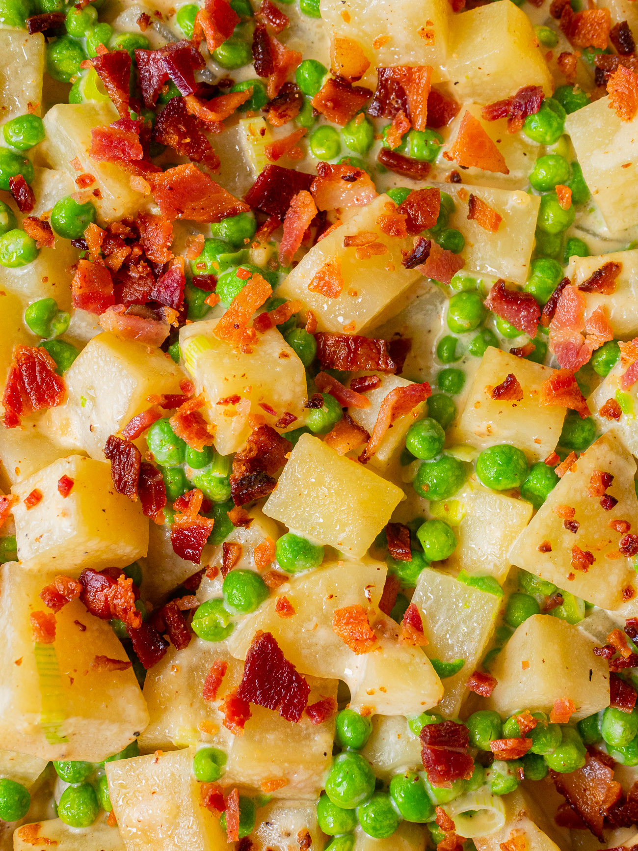 Close up, top down of creamed peas and potatoes with bacon sprinkled on top