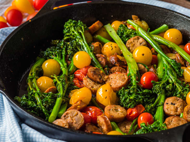 Close up of sausage, tomatoes, and broccoli in a skillet