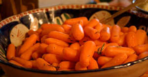 Side shot of cooked carrots in a bowl