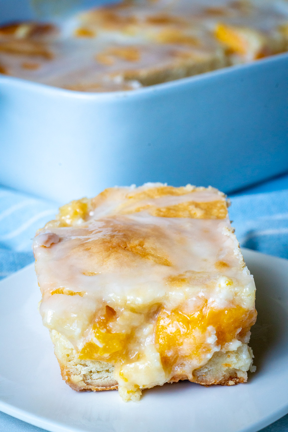 Close up of peaches and cream bars with pan in the background