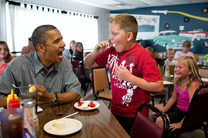 Pres Obama sharing pie with a child