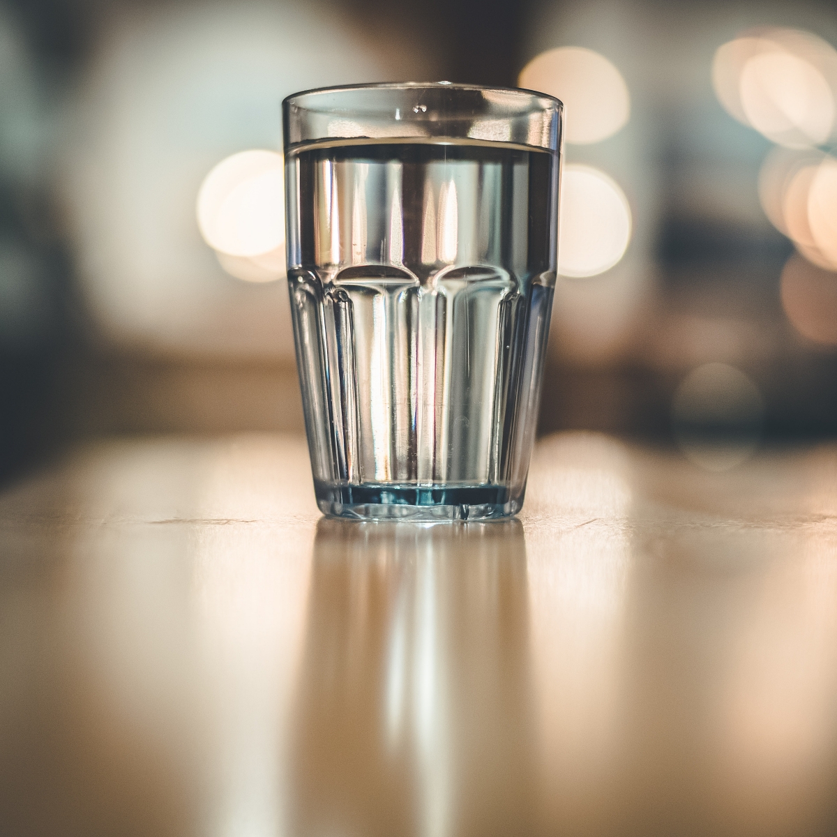 glass of water with lights behind it