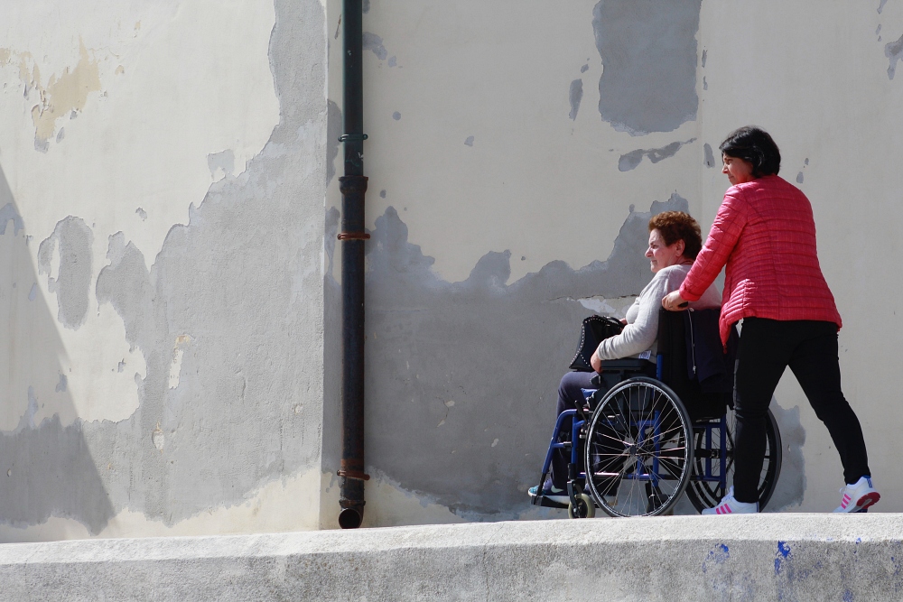 person pushing another person in a wheelchair