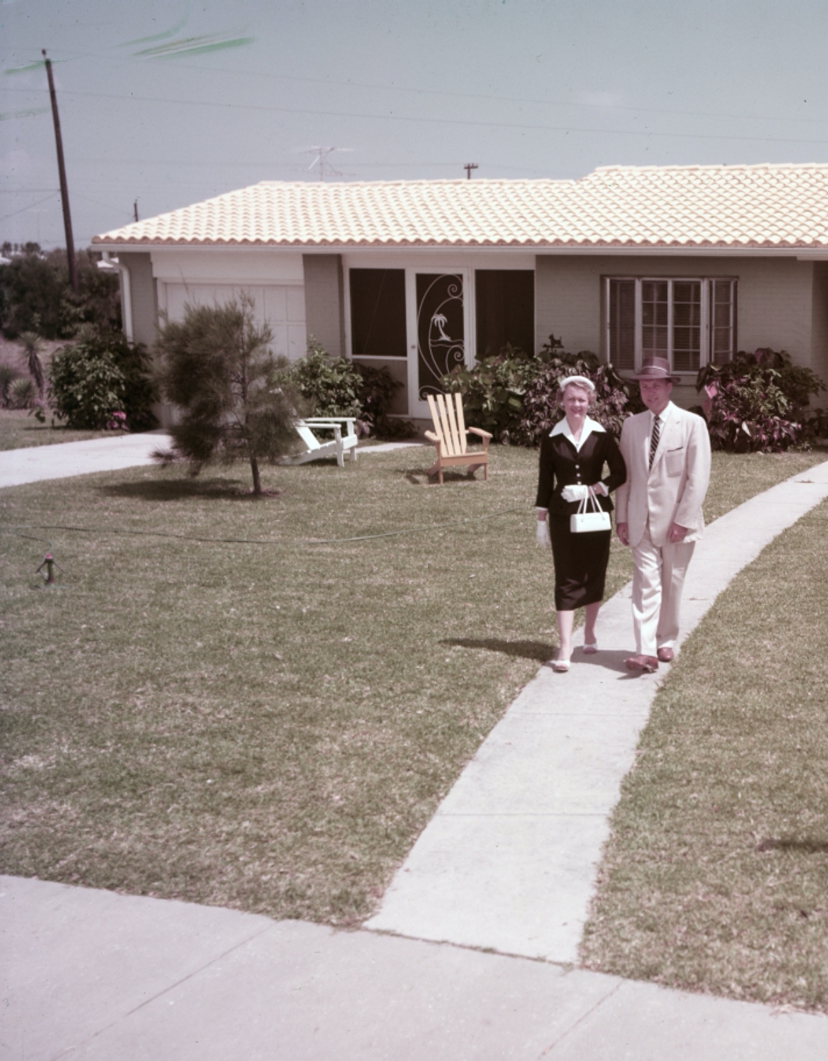 1950s couple in front of their house