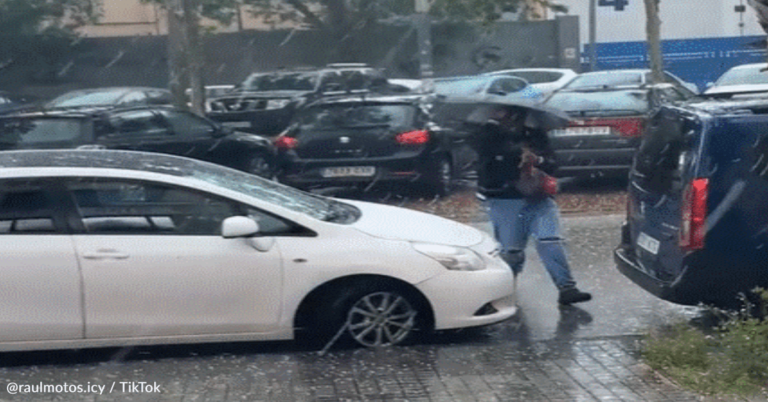 Man Fights To Keep His Umbrella During A Rain Storm