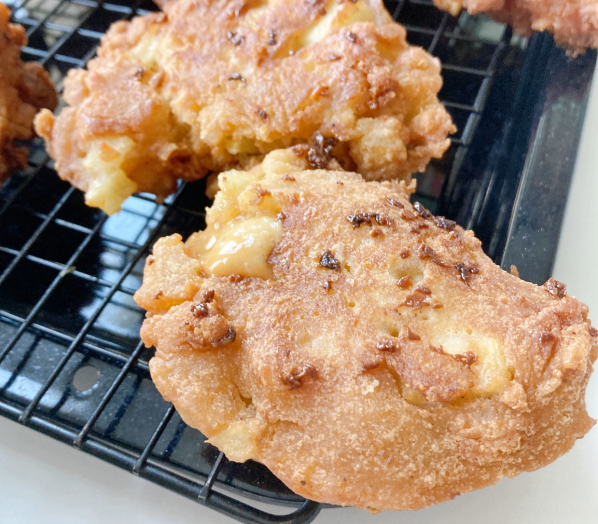 Heat oil to 270˚F in a deep pan. Use 2 spoons to make balls of dough and place them in oil, keeping only 4-6 or so small fritters in the pan at one time to avoid cooling the oil. Fry for 3 minutes on each side or until golden brown. Remove from oil to wire rack to cool.