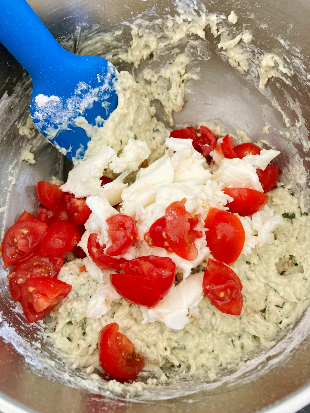Preheat oven to 350˚F. In a large bowl combine flour, salt, pepper, baking powder, baking soda, basil, parsley, and garlic powder. In another bowl combine egg, yogurt, olive oil, milk, and basil paste. Slowly add dry ingredients to wet. Fold in mozzarella and tomatoes.