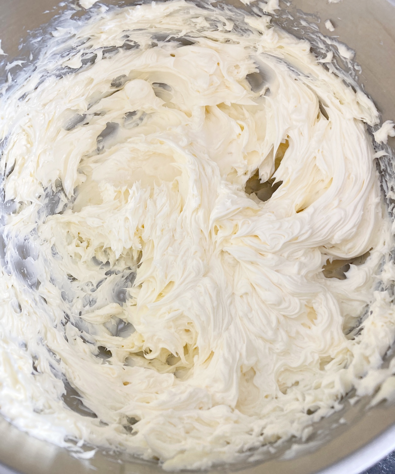 In a large bowl beat butter with electric mixer until light in color, about 5-8 minutes. Add 2 cups powdered sugar and vanilla extract and seeds to butter. Mix until fully combined. Add remaining sugar and cream and beat again until fluffy.