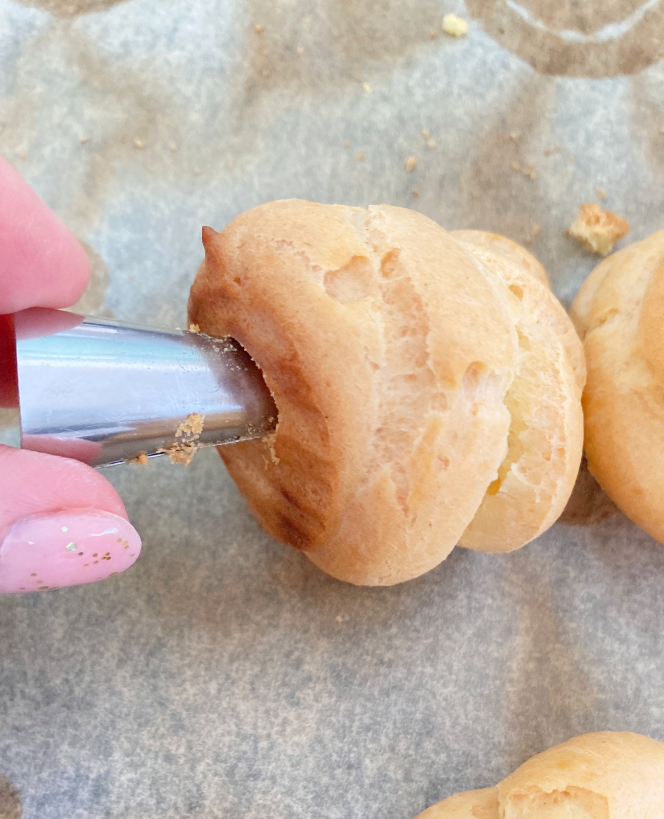 Use a clean piping tip to poke a hole in the bottom of each pastry before setting on a wire rack to cool completely.