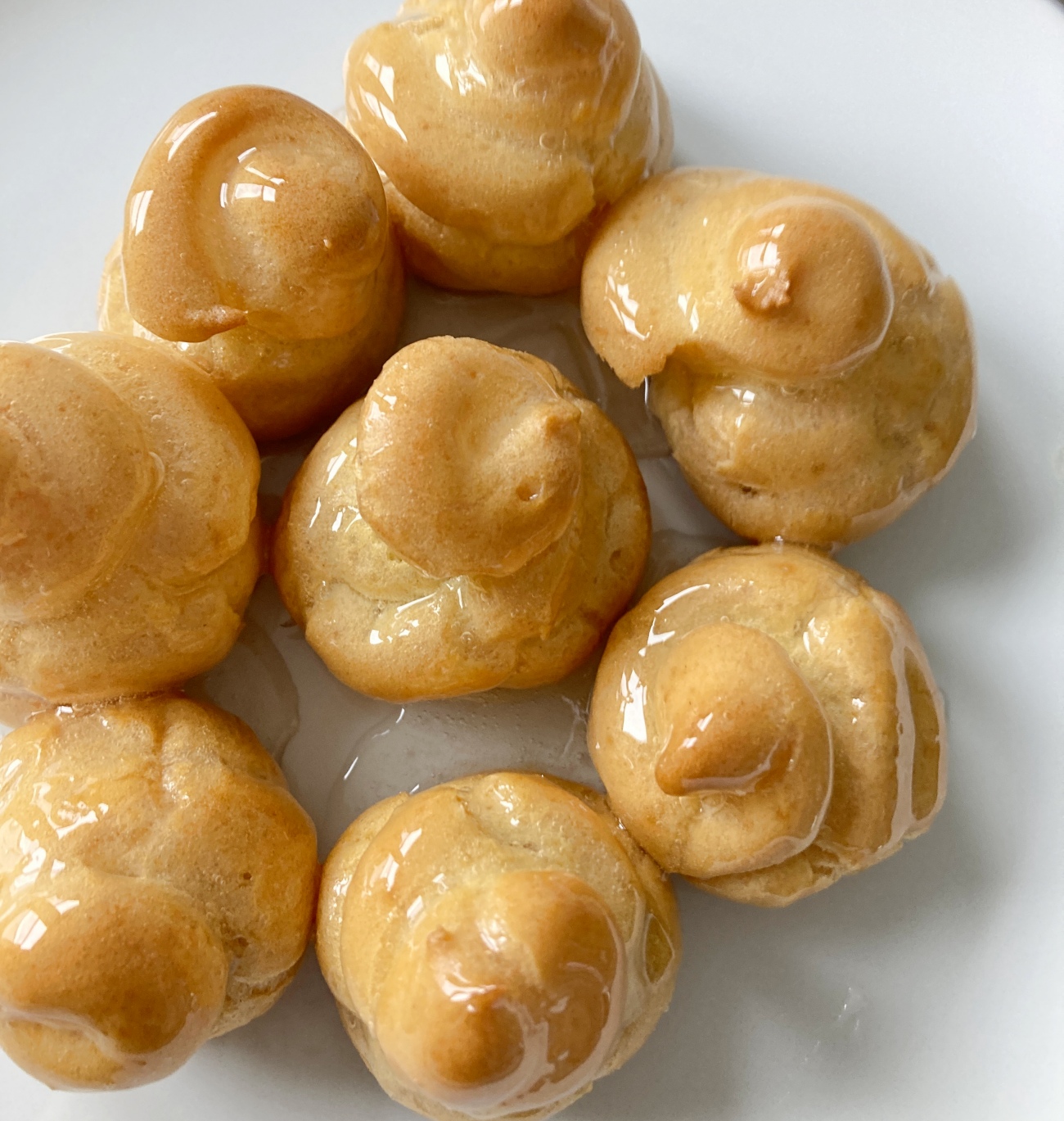 Transfer to a heat-proof bowl and allow to cool for 5 minutes. Dunk each pastry in glaze, then assemble on a plate in a stacked pyramid or cone shape, with 7-10 profiteroles on the first layer and decreasing in number until only one ball is on top. Allow to set for 20 minutes.