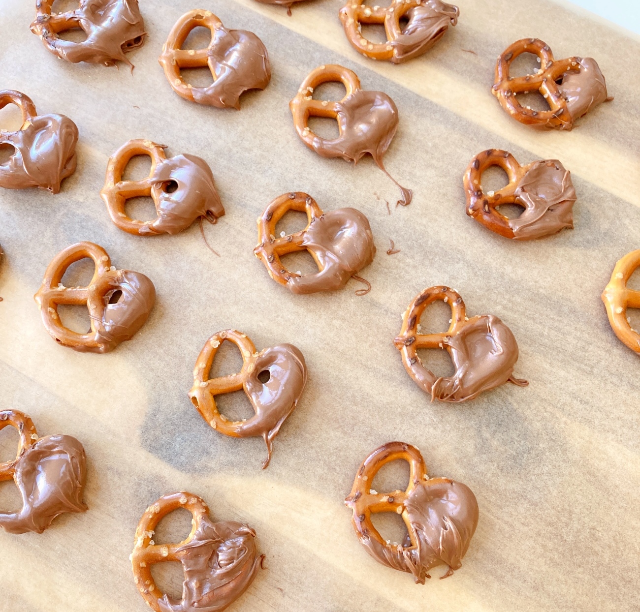 Melt chocolate chips in microwave using 30-second intervals. Dip half the pretzels into melted chocolate, either halfway up pretzels or part way to make a design in the finished cake. Lay on parchment paper lined sheet or on wire cooling rack for 20 minutes, then place in refrigerator to fully harden.