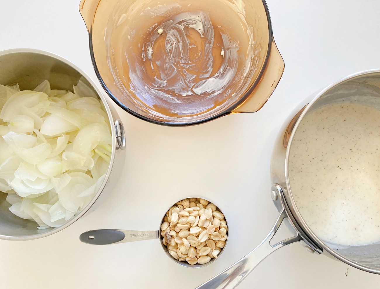 Place a layer of onions on the bottom of a greased 2-quart baking dish. Sprinkle a layer of peanuts and then top with some sauce. Repeat process until onions, sauce, and peanuts are all used up, ending with a sauce layer.