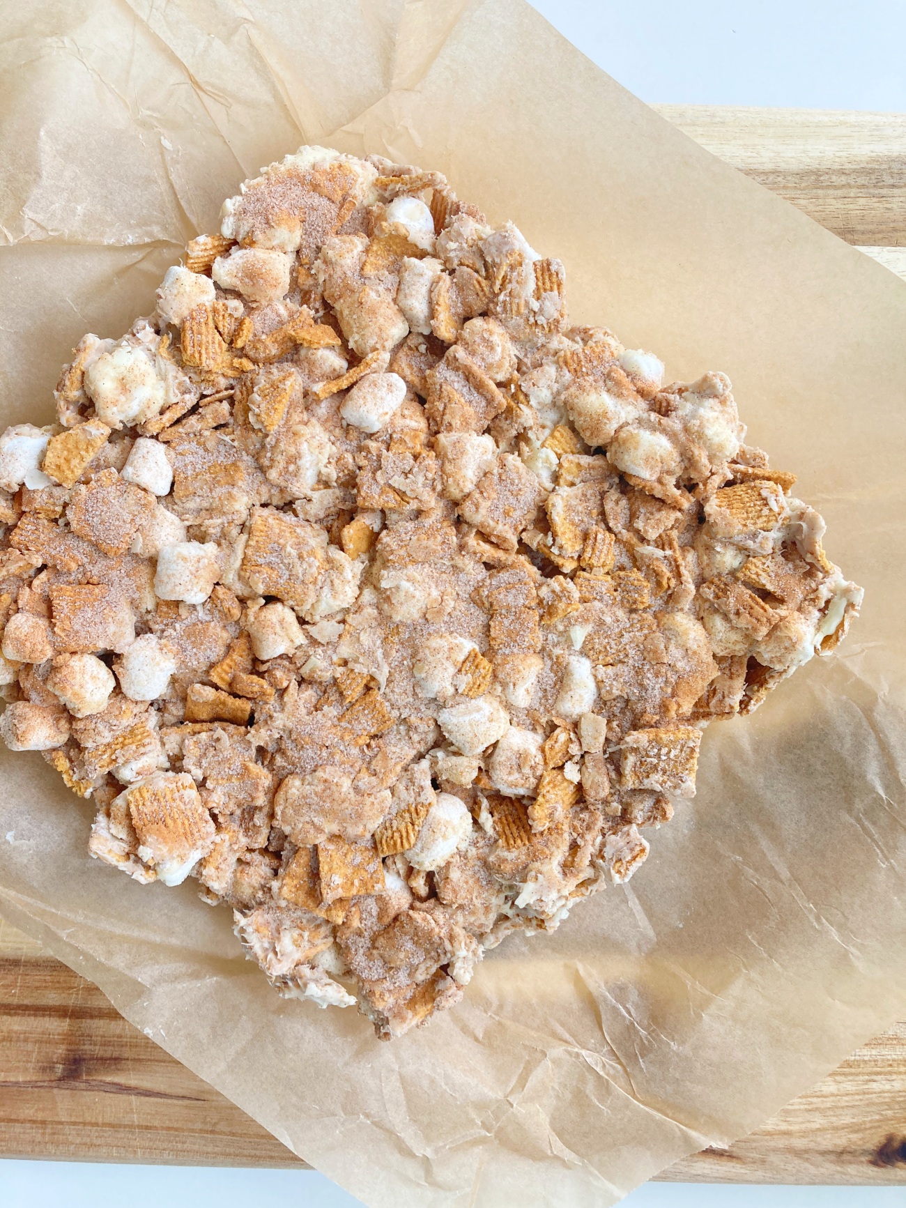 Combine remaining cinnamon and sugar and sprinkle over top before bars set. Allow to chill in refrigerator for at least 30 minutes. Lift out of dish using parchment paper before cutting into 16 squares to serve.