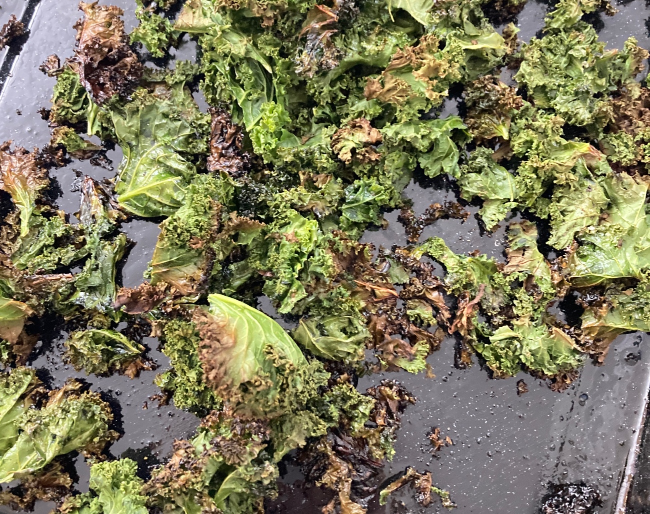 Preheat oven to 425˚F. Add kale to baking sheet and coat with oil. Add salt and pepper to taste. Bake for 12-15 minutes or until edges of kale begin to crisp up.