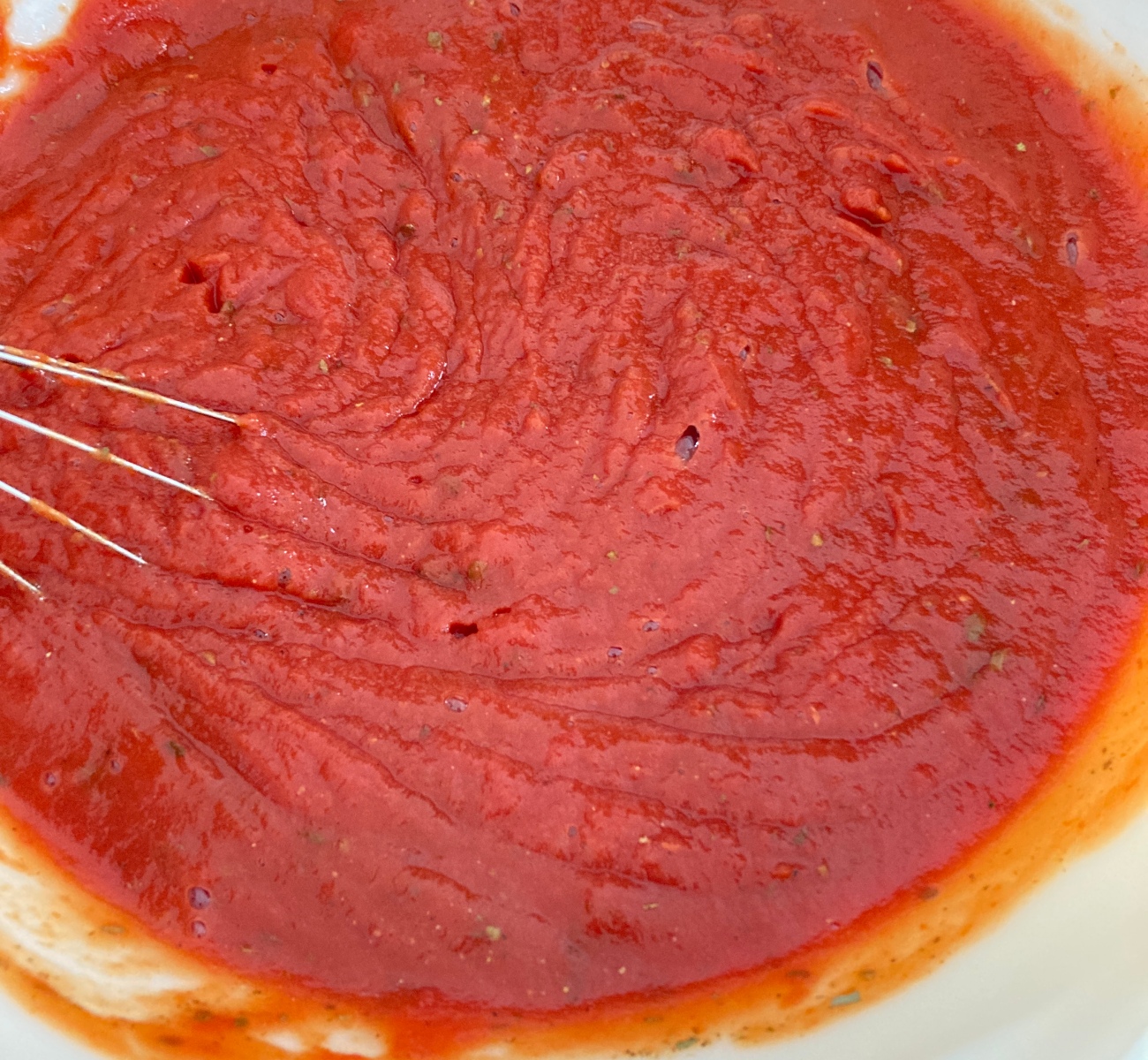 Combine tomato sauce, dried herbs, garlic, and tomato paste in bowl. Add salt and pepper to taste.
