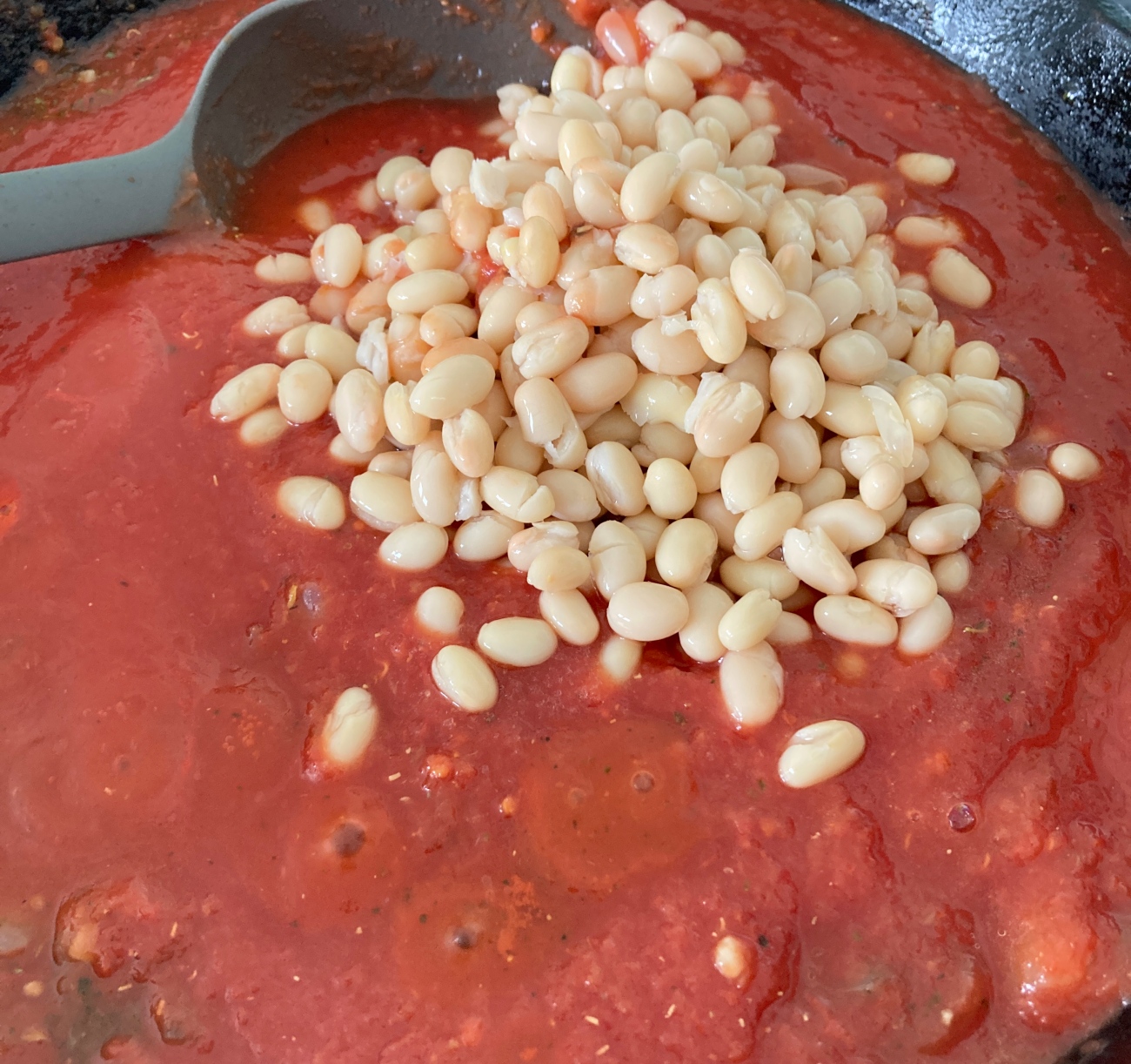 Heat 2 tablespoons olive oil in large skillet over medium and add onion, Italian seasoning, oregano, and 1/2 teaspoon salt. Cook for 7 minutes then add garlic, tomatoes, remaining salt, beans, and broth. Simmer for 10-15 minutes.