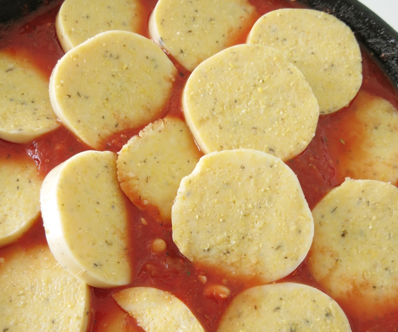 Gently add polenta slices on top and brush with remaining olive oil. Do not submerge polenta in tomato sauce. Place under broiler set to low for 4-6 minutes or until polenta just begins to brown on top. Do not step away from stove at this point and check on skillet every minute or two.