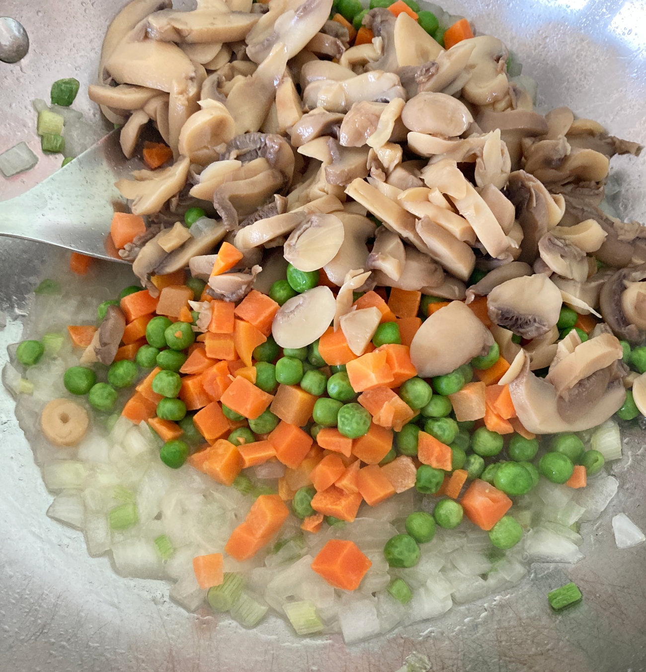 Add 2 tablespoons oil to large skillet or wok. Heat over high and add yellow onion and white parts of green onions. Cook for 2 minutes, then add water. Add peas, carrots, and mushrooms to pan. Cook for 4 minutes, stirring often.