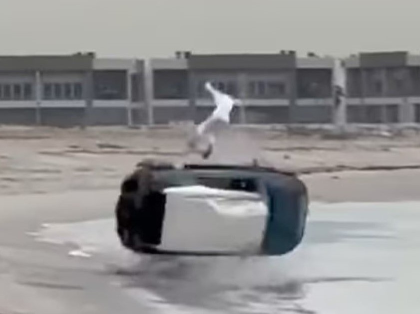 Still of the flipping vehicle with the driver in mid- air.