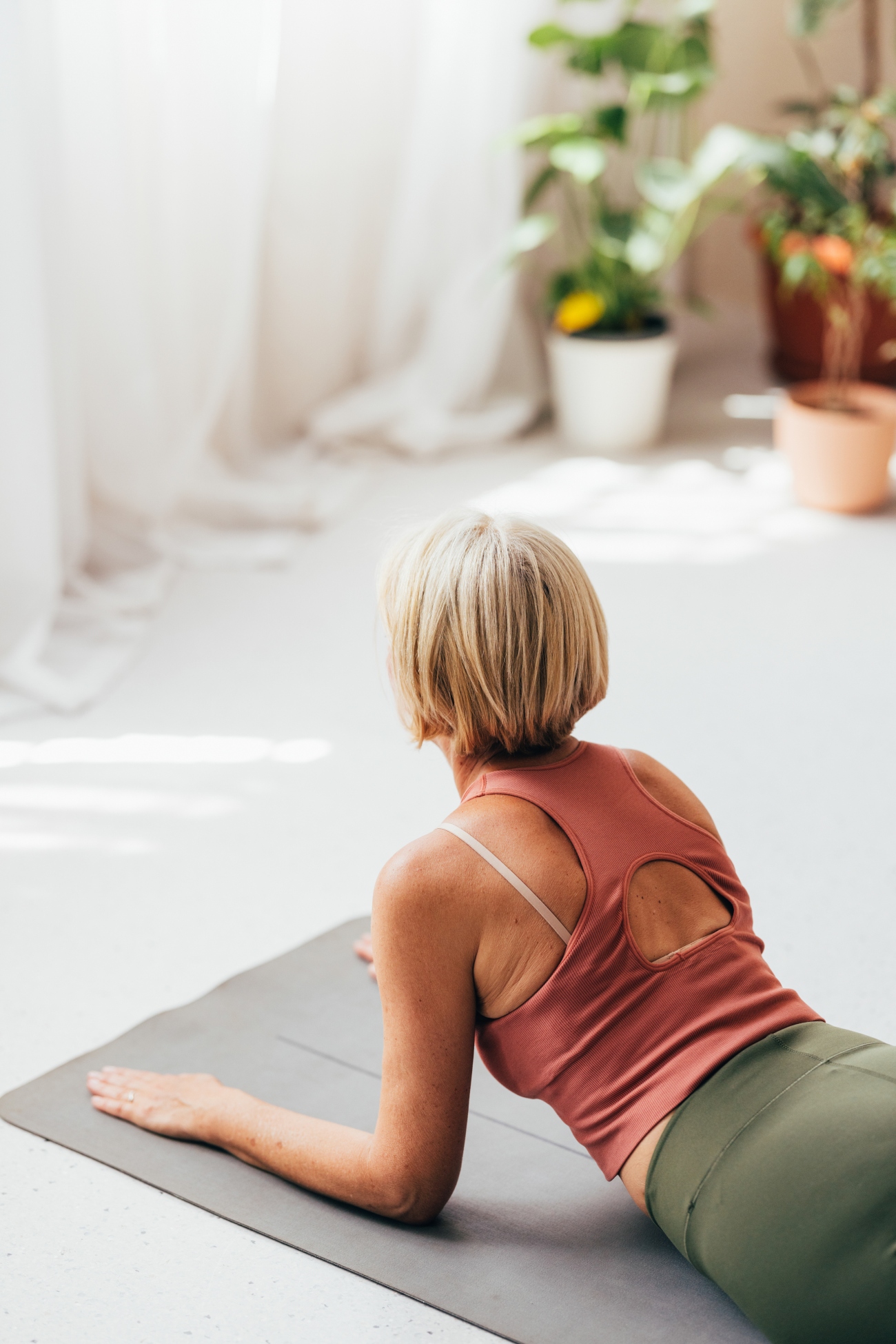 Woman Doing Baby Cobra Yoga Pose on Mat