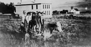 1907 Frontier children on cow