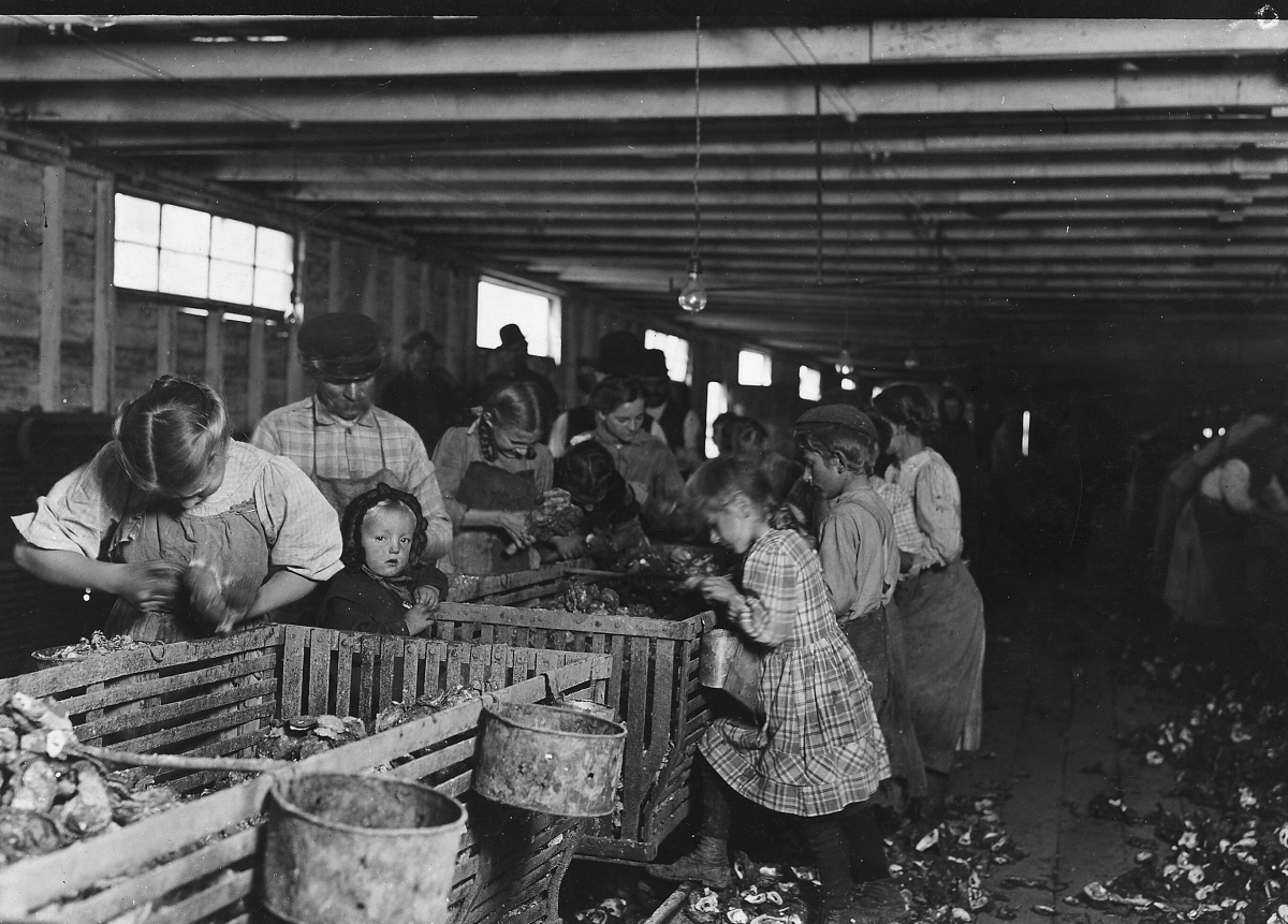 women and children shucking oysters for large scale food production