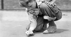 little boy playing marbles