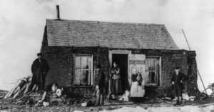pioneer family in front of sod house