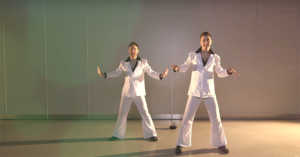 two men in leisure suit costumes performing disco dance moves
