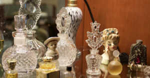 collection of lady head vases and vintage perfume bottles on mirrored surface