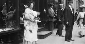 destitute woman with baby selling her wares on the streets of NYC in 1910