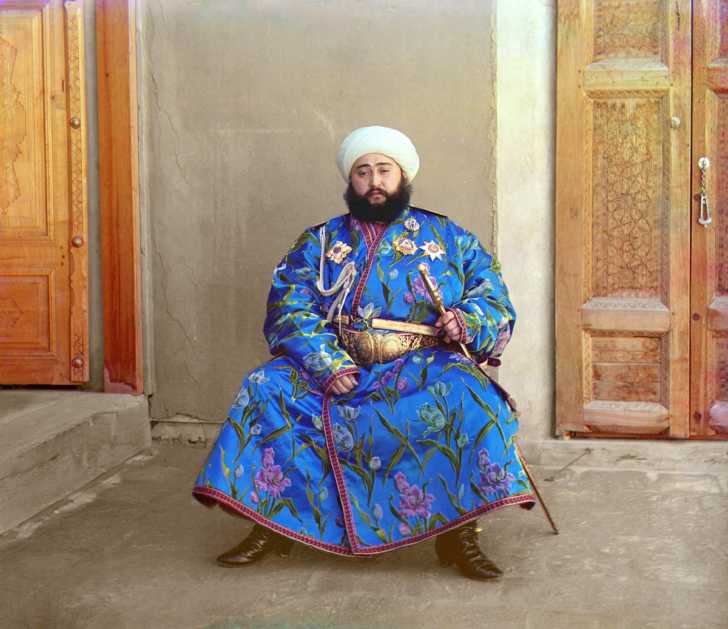 Alim Khan, Emir of Bukhara, seated holding sword.