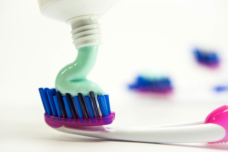 toothpaste being applied to a toothbrush
