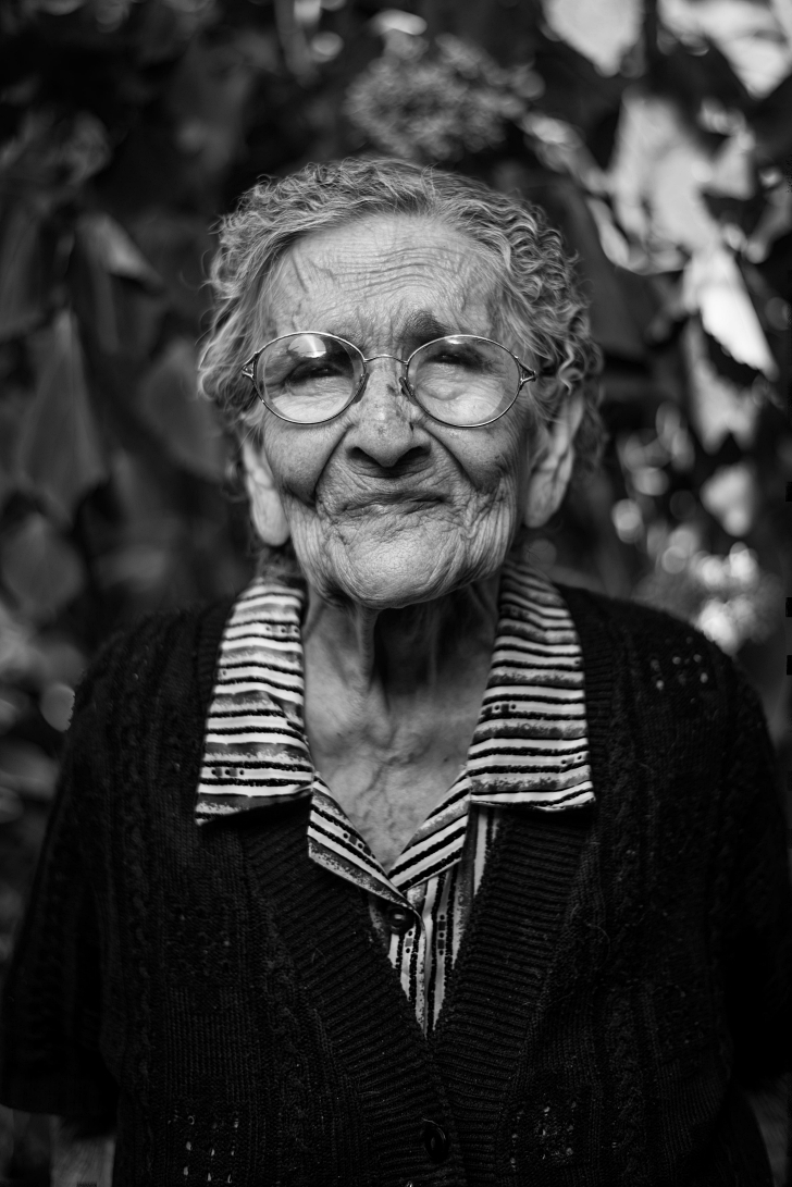 elderly woman with glasses and an expressive face