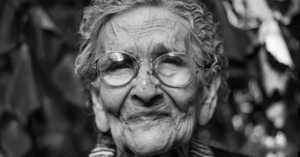 elderly woman with glasses and an expressive face