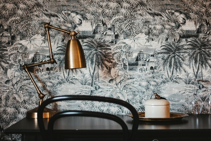 toile wallpaper with modern brass lamp