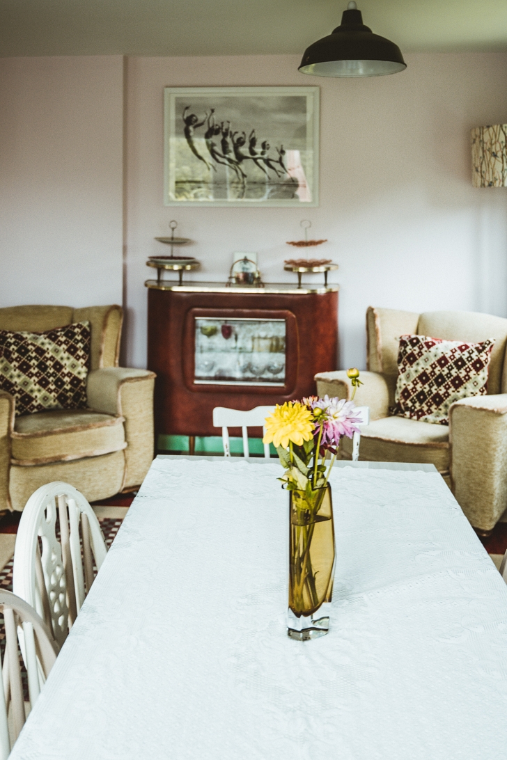 living and dining room filled with a mix of vintage furniture styles