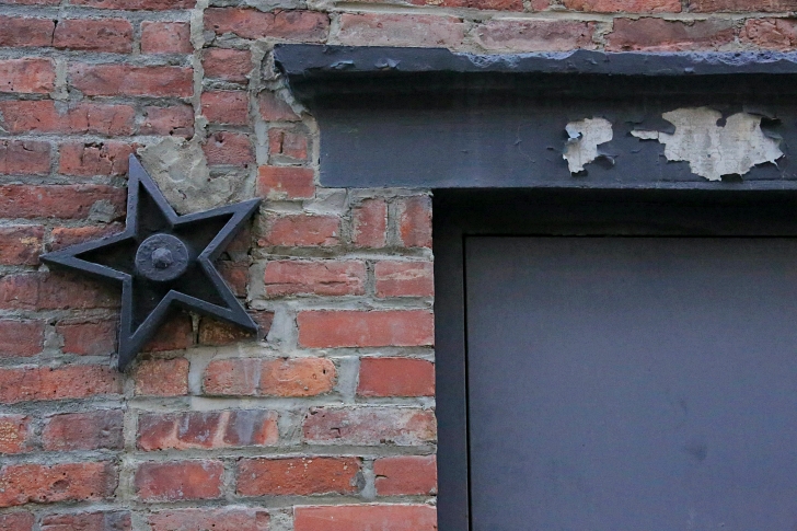 black metal star on old brick building