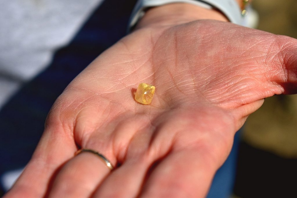 yellow diamond in palm of a hand