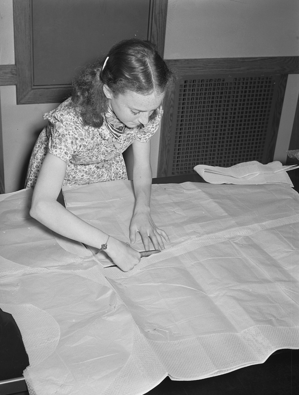 girl cutting out patterns pieces in home ec class