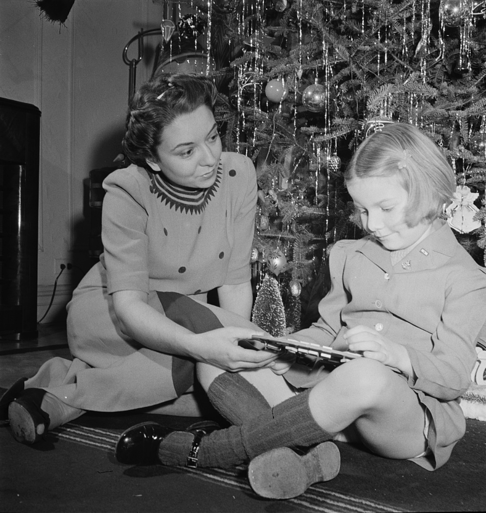 woman and child sitting near a Christmas tree 1942