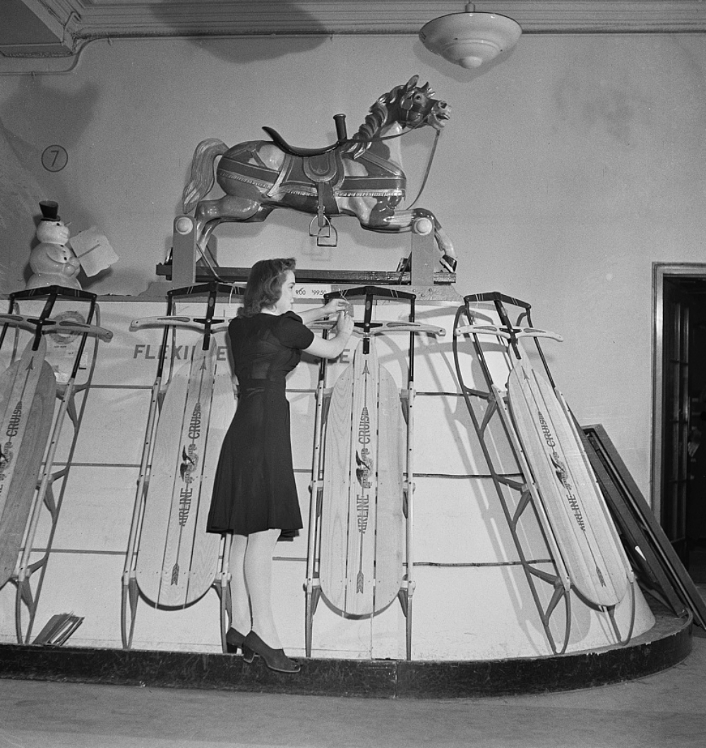Macys shop girl putting a price tag on a sled in December 1942