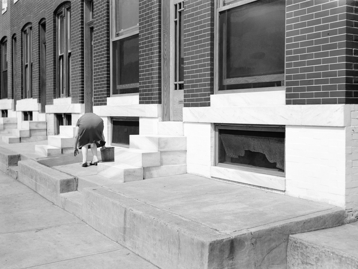 woman cleaning front steps in 1940s