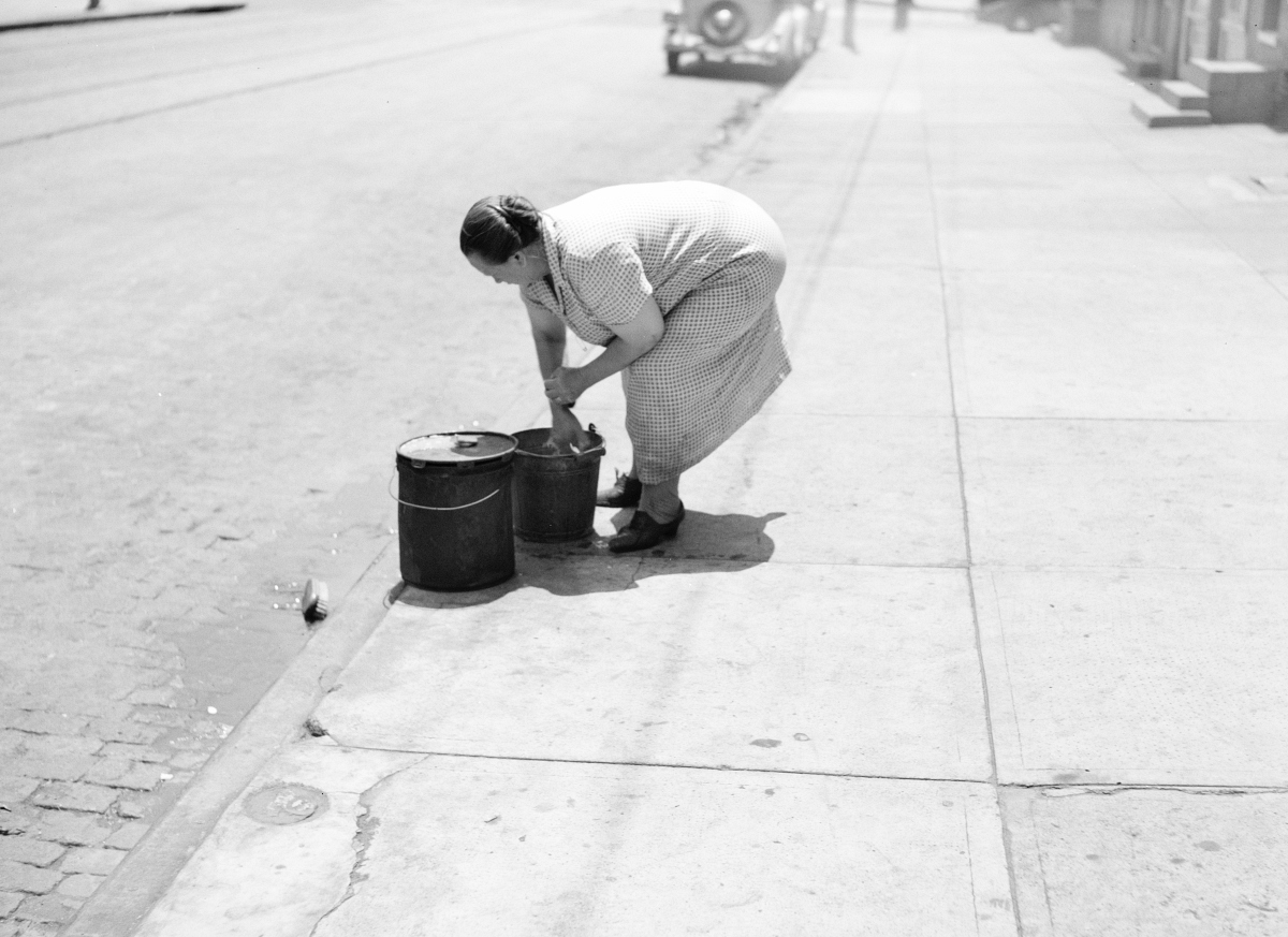 woman emptying wash water in gutter