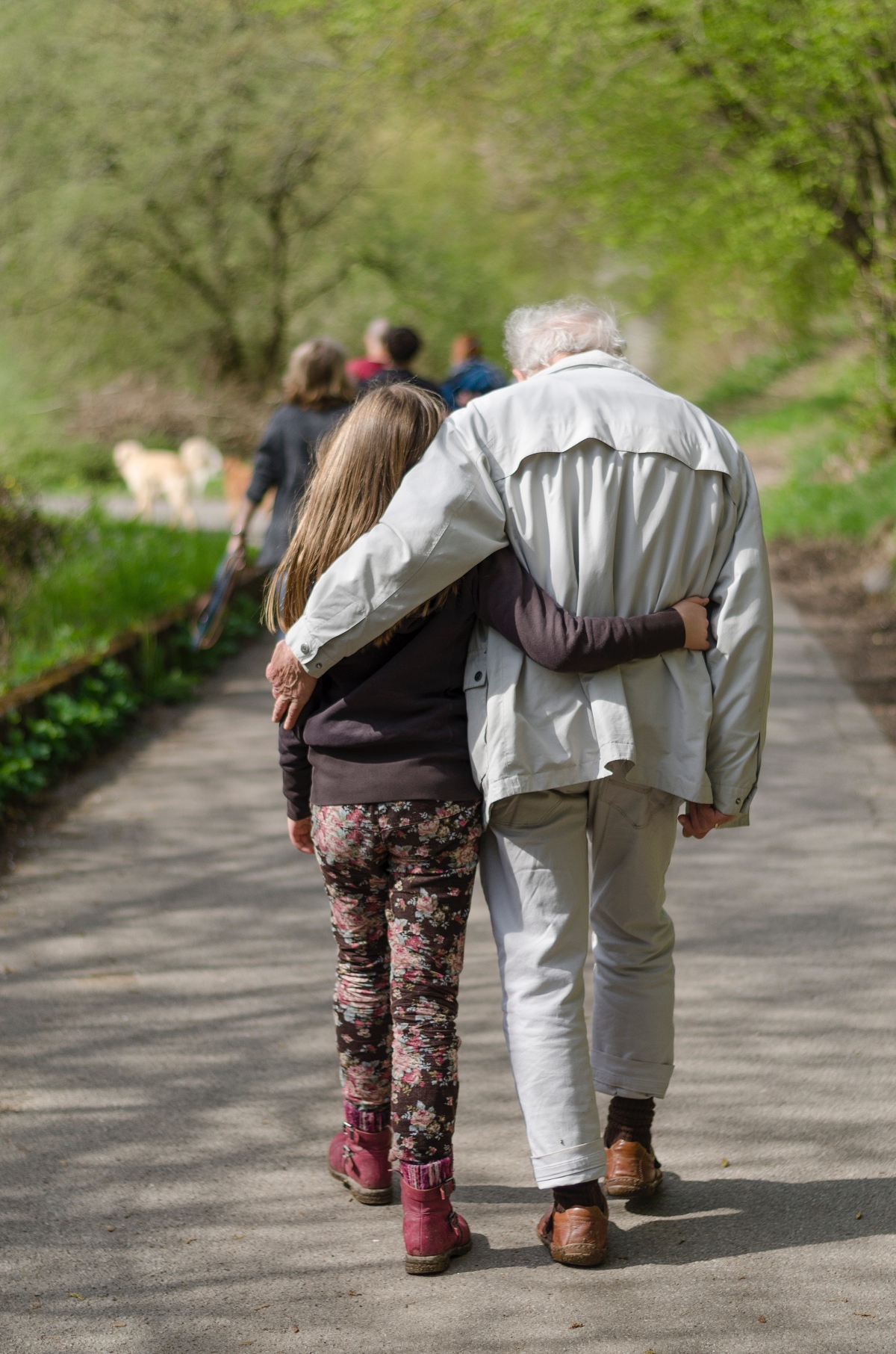 elderly man walking with a young girl