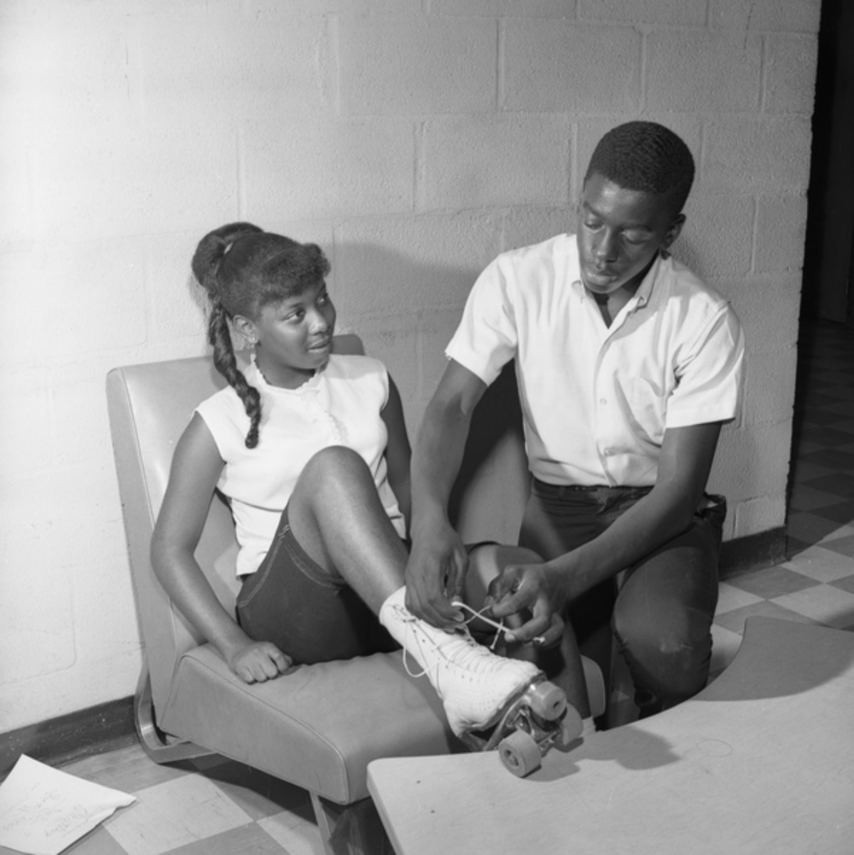 boy helping a girl with her roller skates