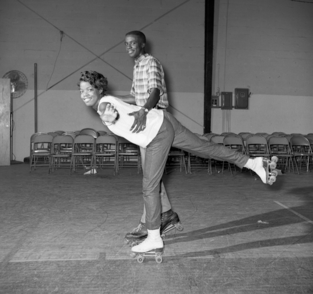 two young people roller skating in the 1960s