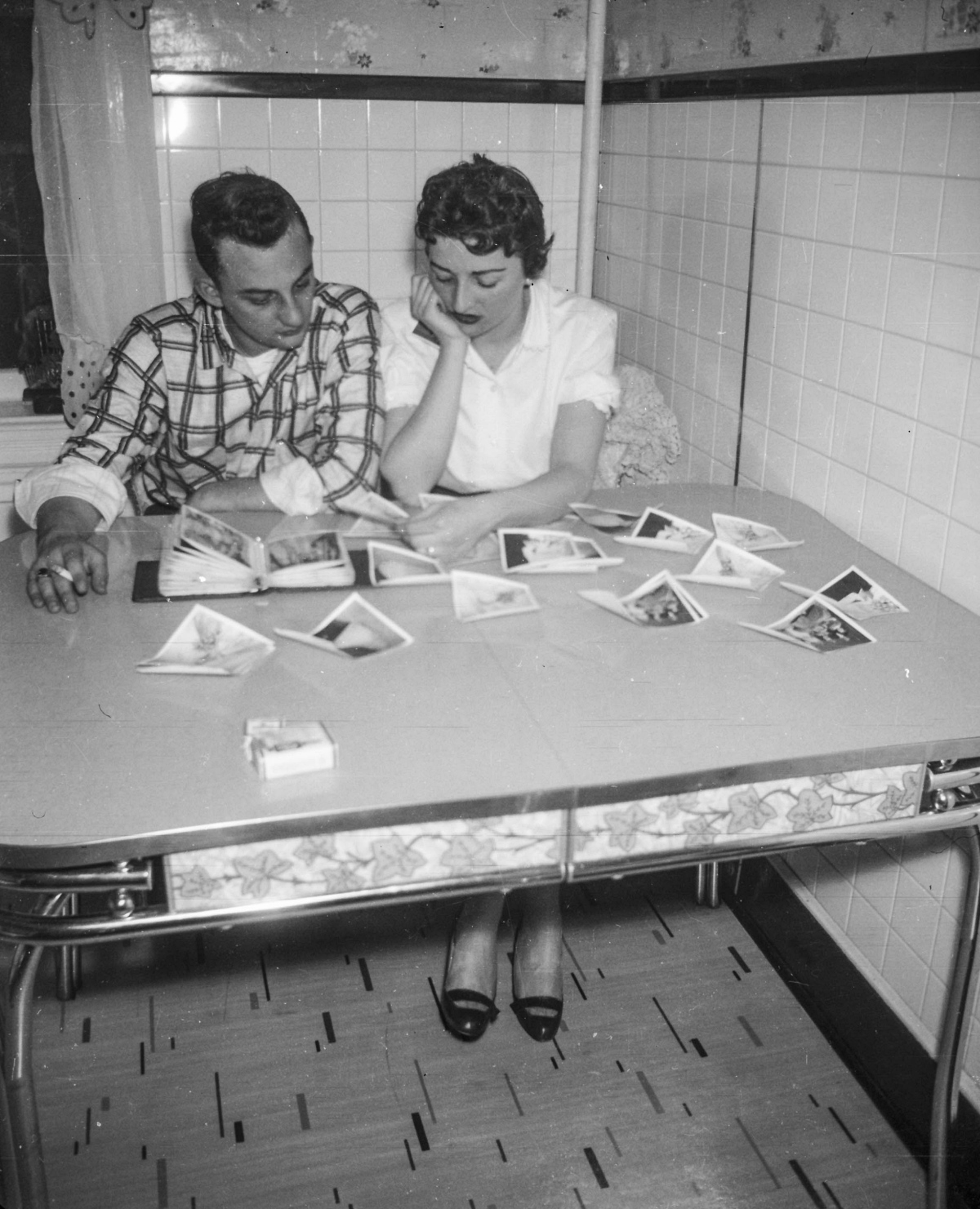 man and woman looking at photos in a 1950s kitchen