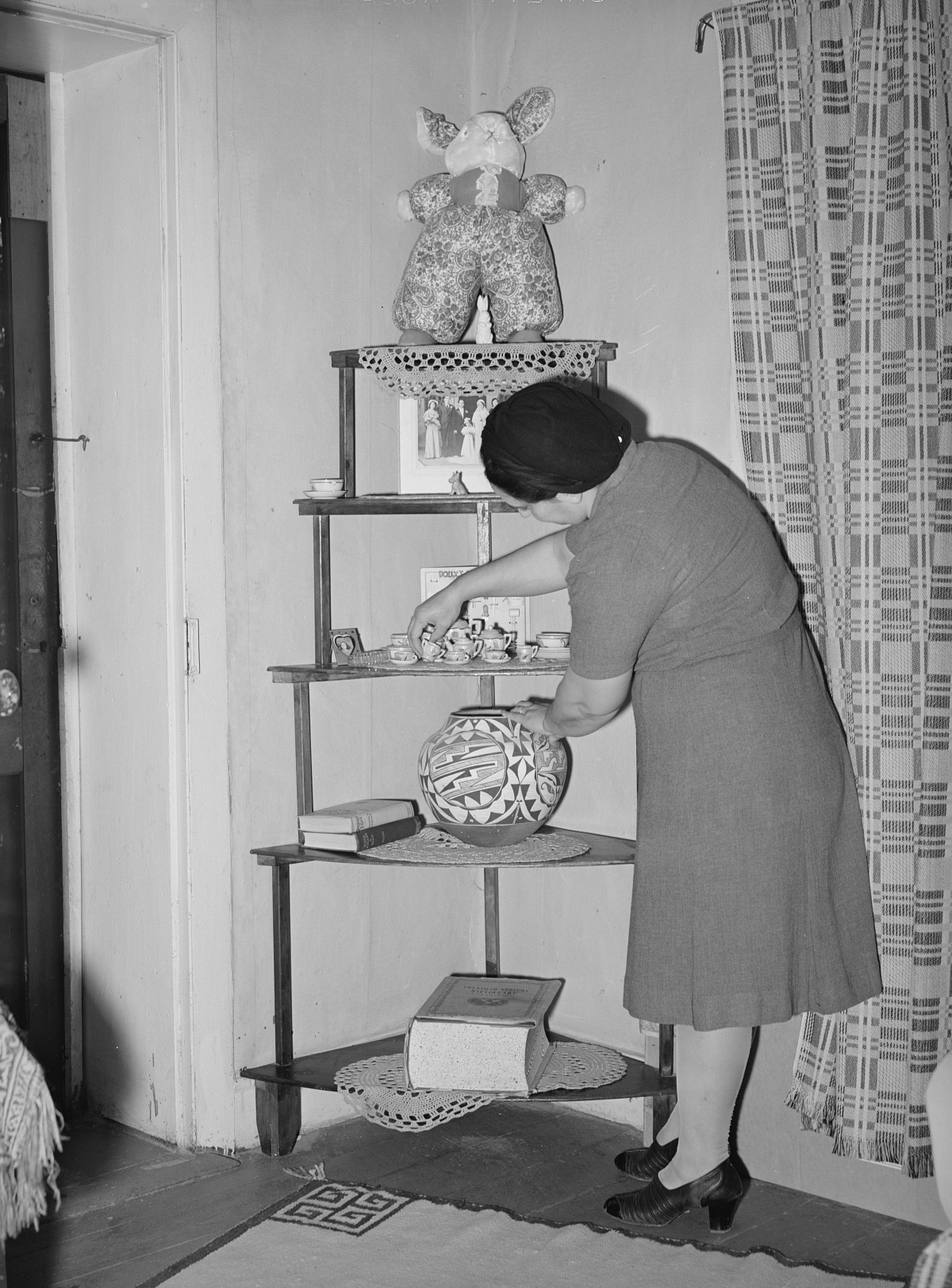 1930s woman arranging knick knacks on a shelf